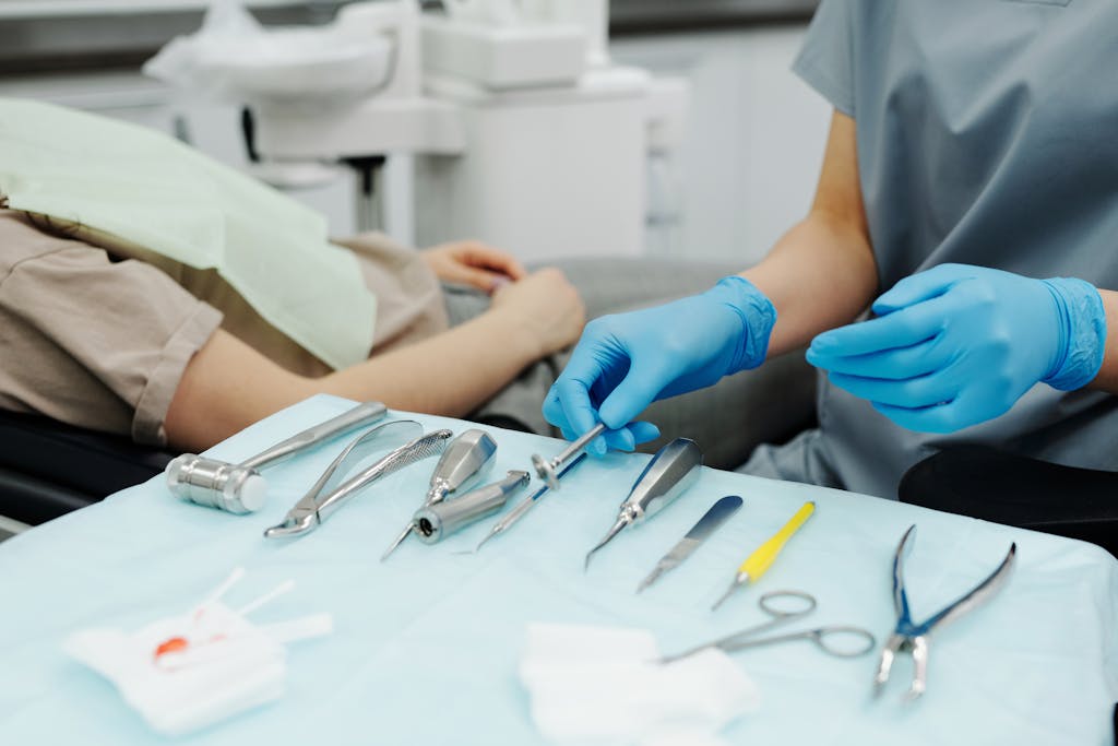 Dentist wearing gloves prepares tools for patient care in a modern clinic.