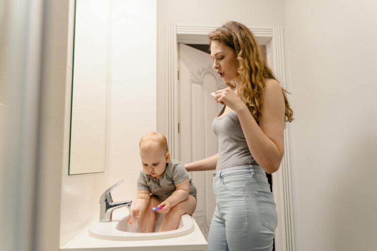 Parent gently cleaning infant’s gums