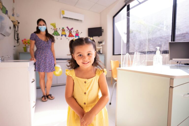 Parent and child smiling during a visit with a friendly pediatric dentist