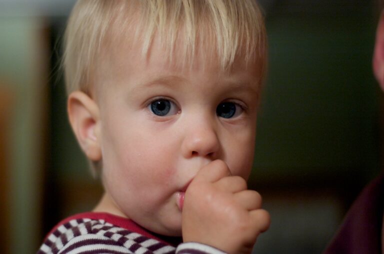 Toddler sucking thumb while resting, a common habit affecting baby teeth alignment